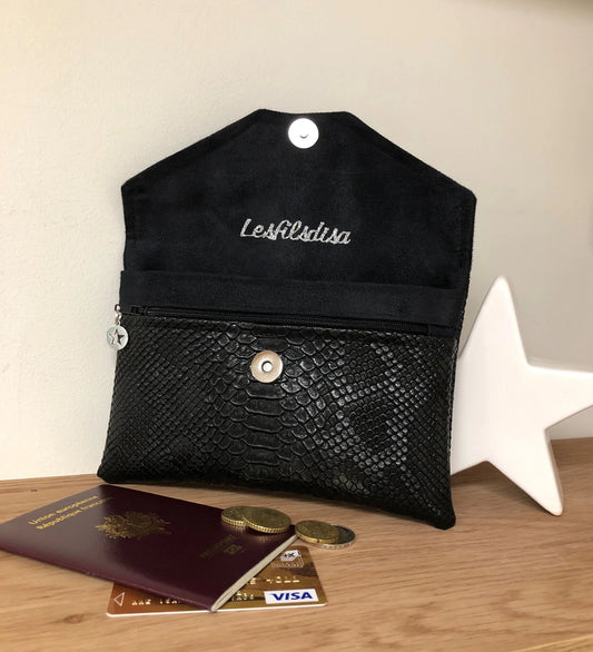 Le compagnon de sac noir aspect reptile, présenté ouvert, avec monnaie, passeport et carte bancaire.