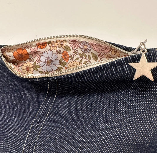 Détail de la doublure intérieure fleurie de la pochette en denim brut.