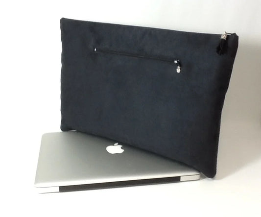 La pochette ordinateur noir et argenté aspect reptile, avec poche chargeur à l'arrière.