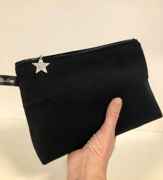 La pochette en velours côtelé noir fermée