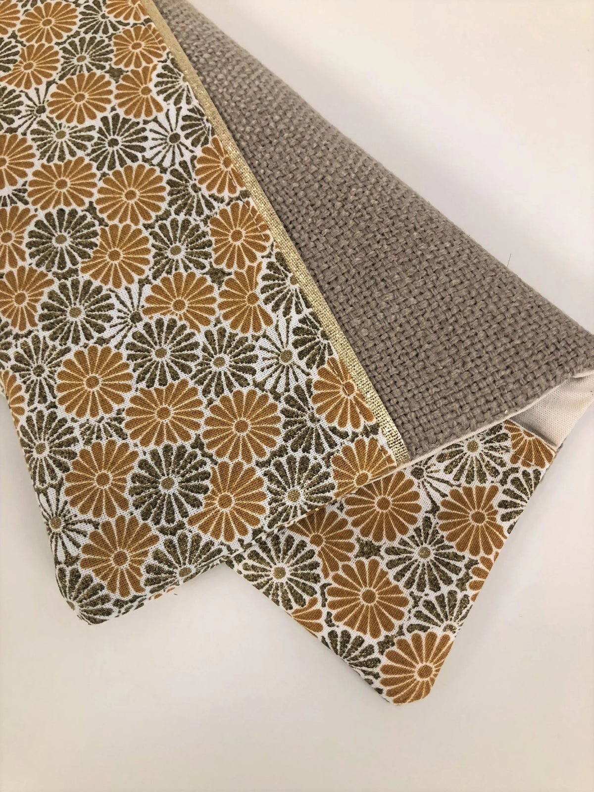 Le porte-chéquier beige à fleurs moutarde et bronze, vide.