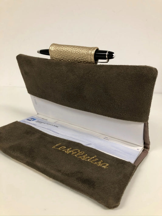 Le porte-chéquier marron et doré avec porte-stylo, ouvert.
