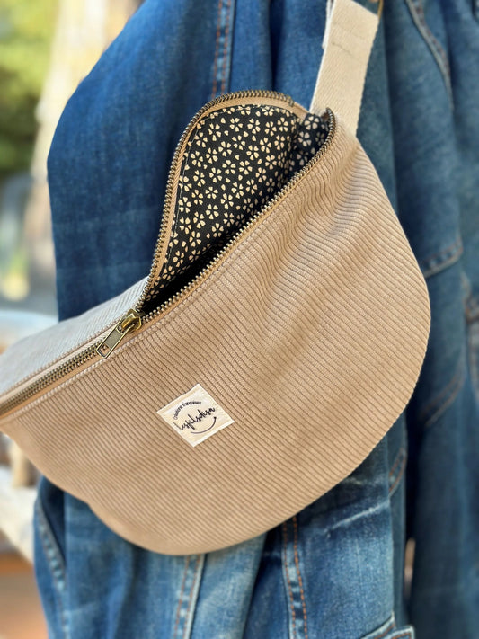 Le sac banane en velours côtelé beige, entrouvert.