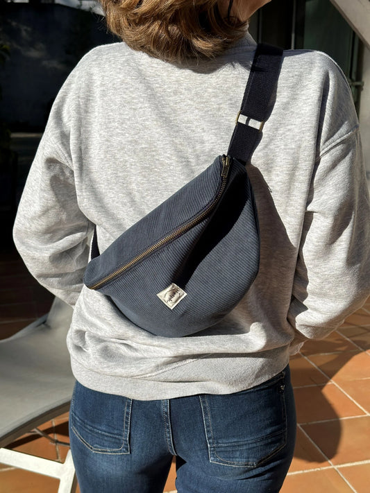 Le sac banane en velours côtelé bleu canard, porté en travers.