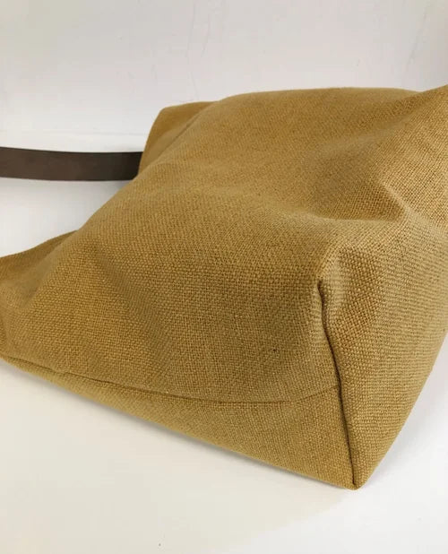 Le fond du sac Hobo en lin moutarde et son anse en cuir marron