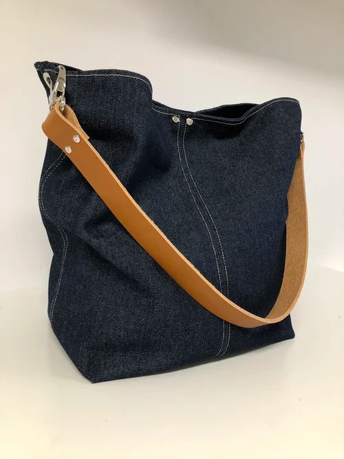 Le sac hobo en toile denim brut et son anse en cuir fauve, vue d'ensemble