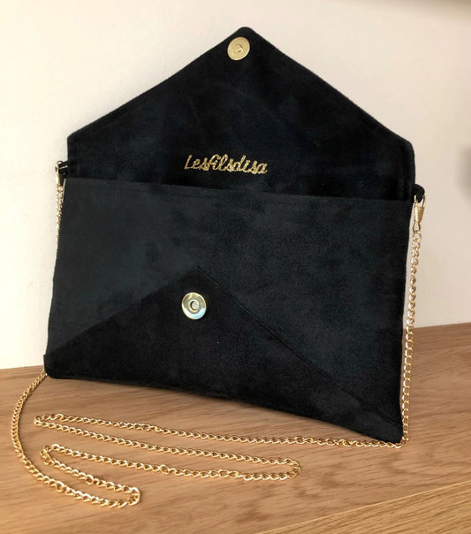 Le sac pochette Isa en suédine noire et paillettes dorées, ouvert, avec chainette amovible.