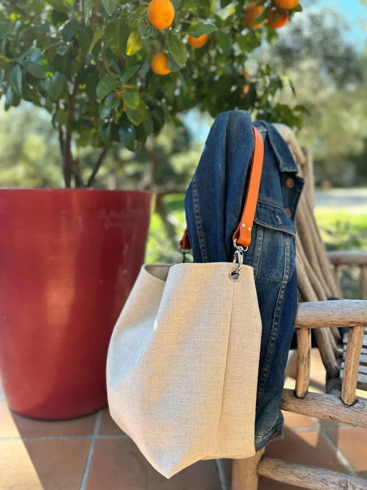 Le sac Hobo en lin ivoire et anse en cuir orange