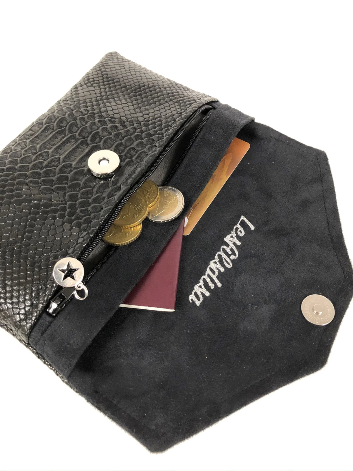 Le compagnon de sac noir aspect reptile, ouvert, contenant monnaie, passeport et carte bancaire.
