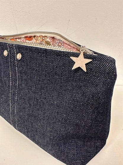 Vue détaillée de la pochette en denim brut, avec ses surpiqures contrastantes.