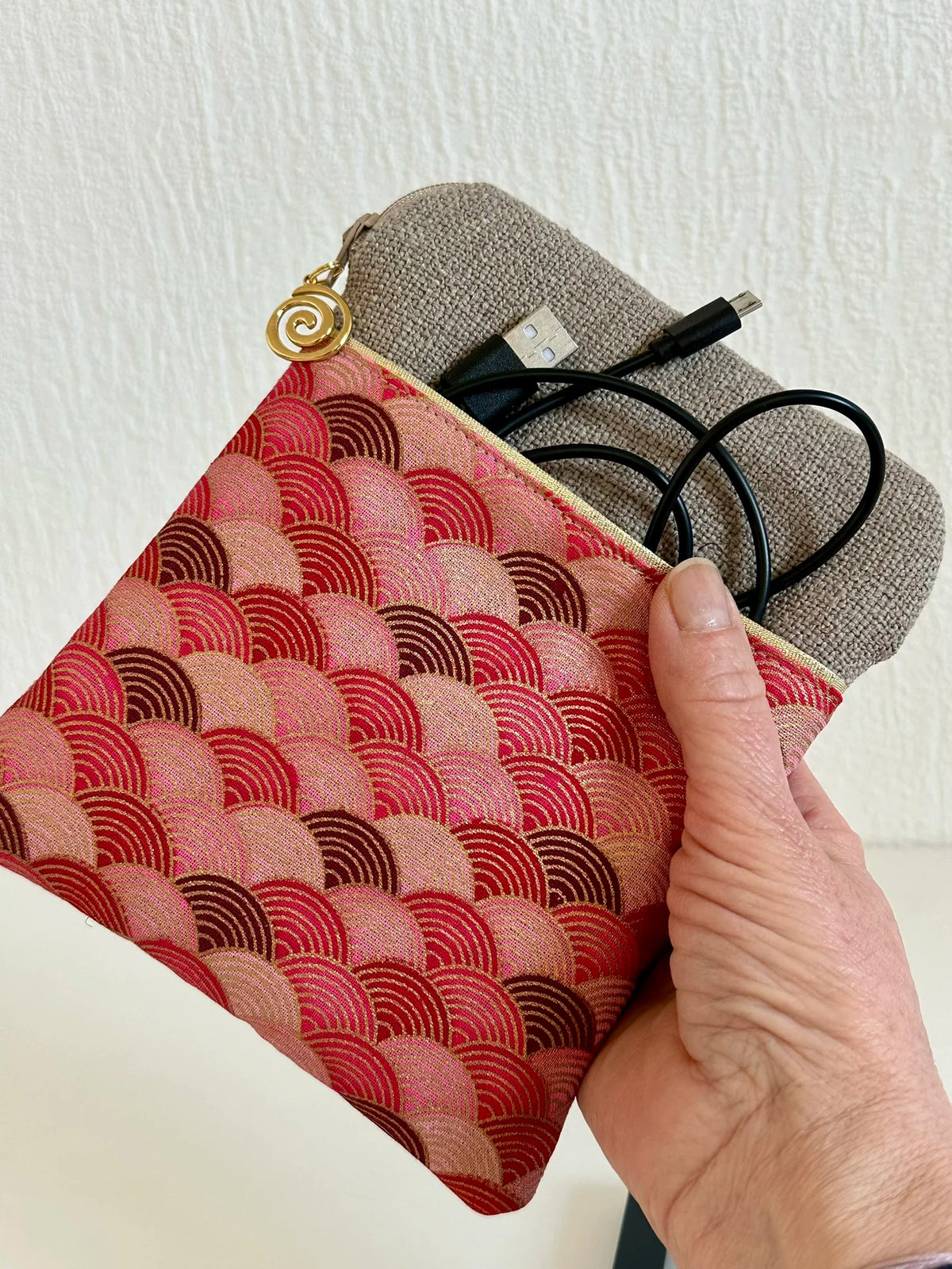 La pochette liseuse en lin et tissu japonais Seigaiha rouge tenue en main