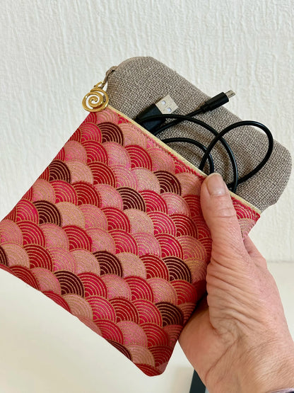 La pochette liseuse en lin et tissu japonais Seigaiha rouge tenue en main