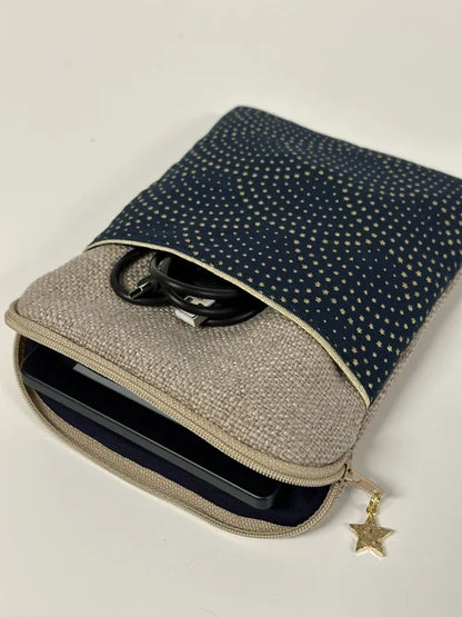 La pochette liseuse en lin et tissu bleu à étoiles dorées, ouverte.