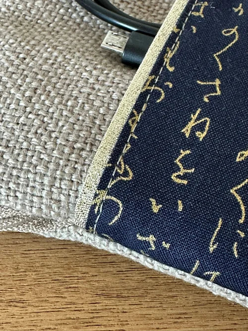 Vue détaillée du tissu japonais de La pochette liseuse en lin et tissu japonais bleu à écriture dorée