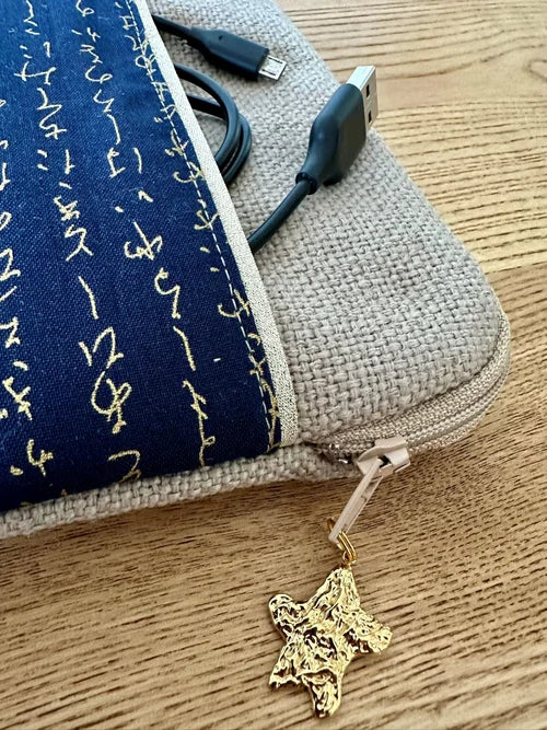 L'ouverture élargie de la pochette liseuse en lin et tissu japonais bleu à écriture dorée