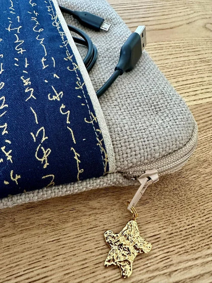 L'ouverture élargie de la pochette liseuse en lin et tissu japonais bleu à écriture dorée