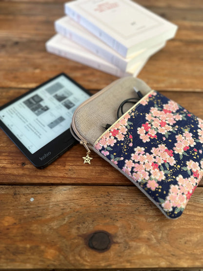 La pochette liseuse en lin et tissu japonais Sakura fleuri, posée à coté d'une Kobo Libra.