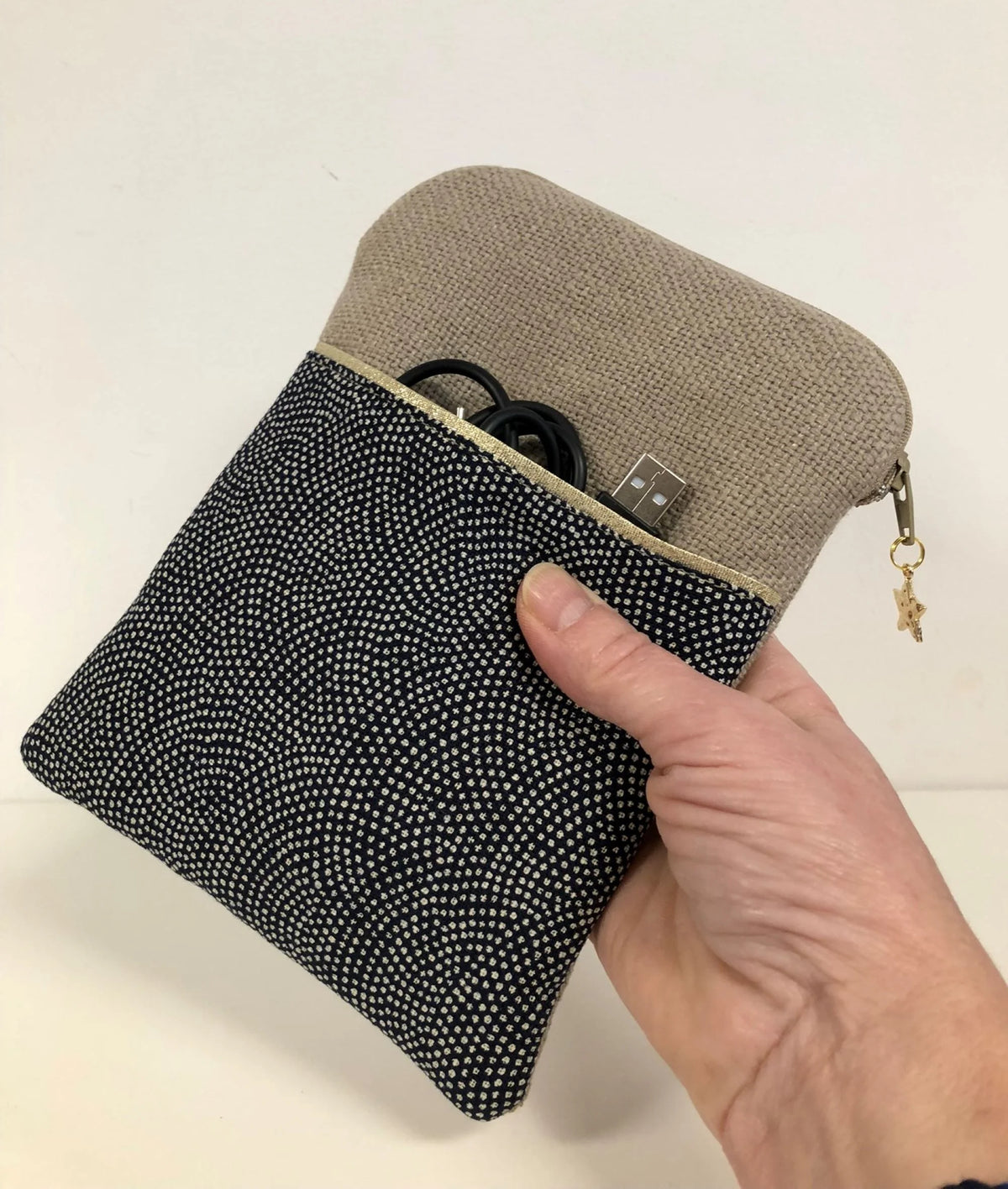 La pochette liseuse en lin et tissu japonais Komon, tenue en main.