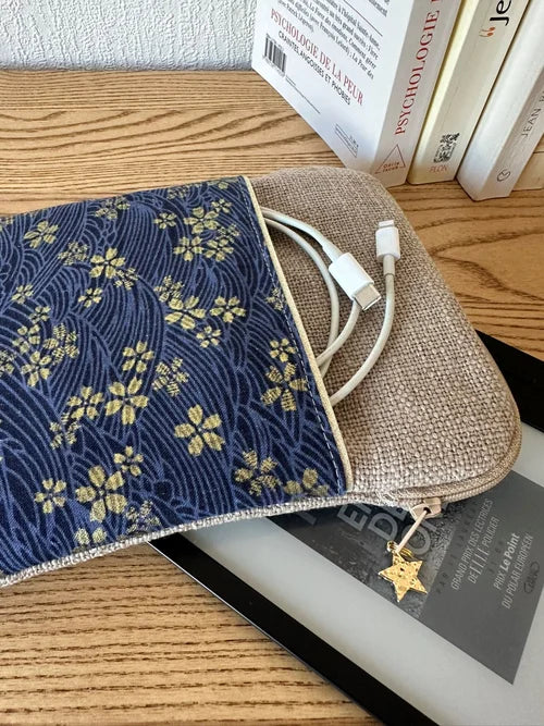 Le cable de recharge dans la poche avant de la pochette liseuse en lin et tissu japonais Sakura bleu.