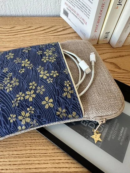 Le cable de recharge dans la poche avant de la pochette liseuse en lin et tissu japonais Sakura bleu.