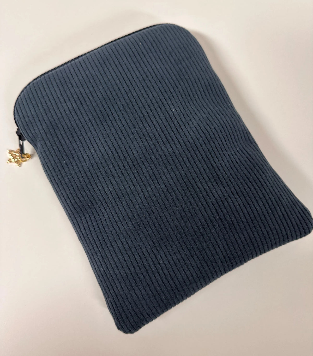 Le dos de la pochette liseuse en velours cotelé bleu canard.