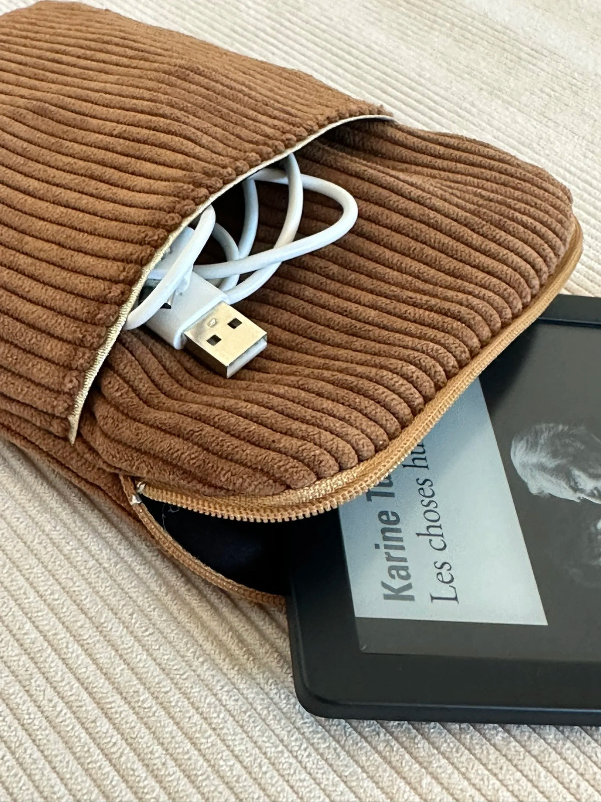 La pochette liseuse en velours cotelé caramel entrouverte.