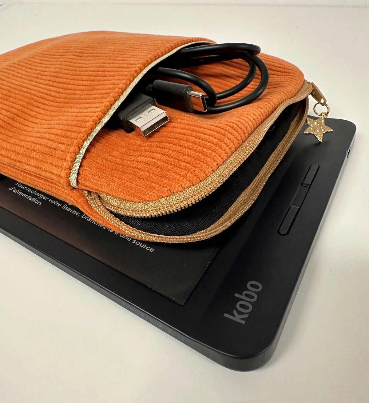 La pochette liseuse en velours  orange, entrouverte.