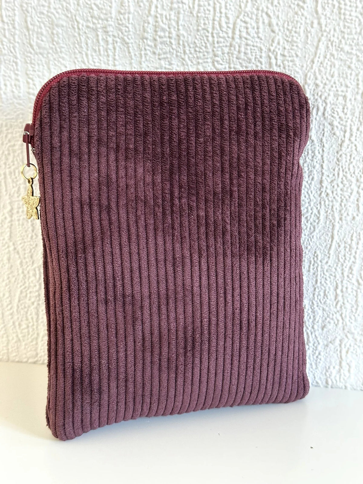 Le dos de la pochette liseuse en velours prune.