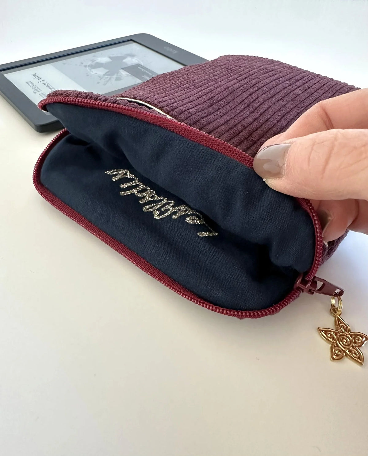 La doublure intérieure en tissu coton doux de la pochette liseuse en velours prune.