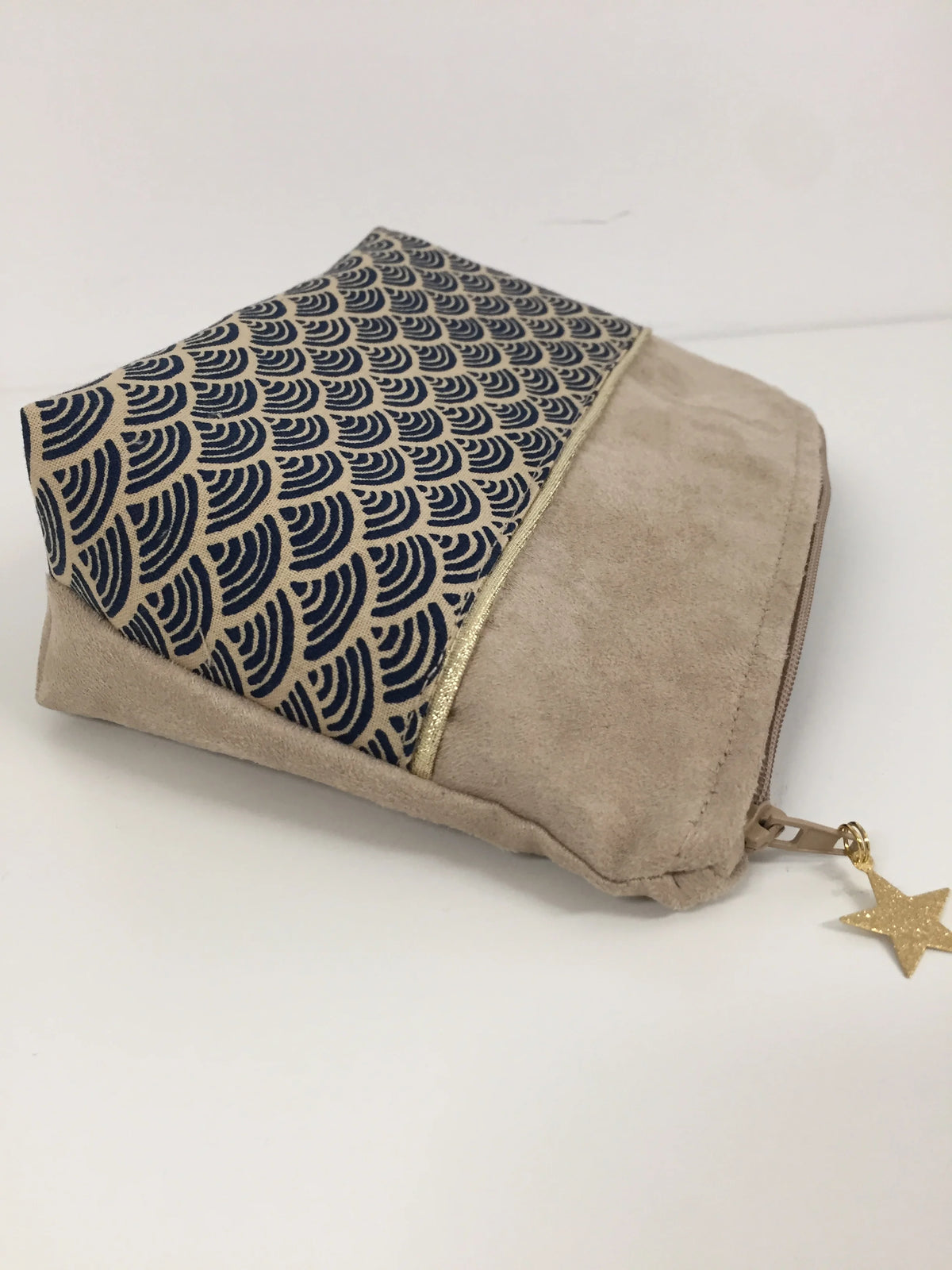 La pochette à maquillage beige en tissu japonais Seigaiha bleu marine, vue de coté.