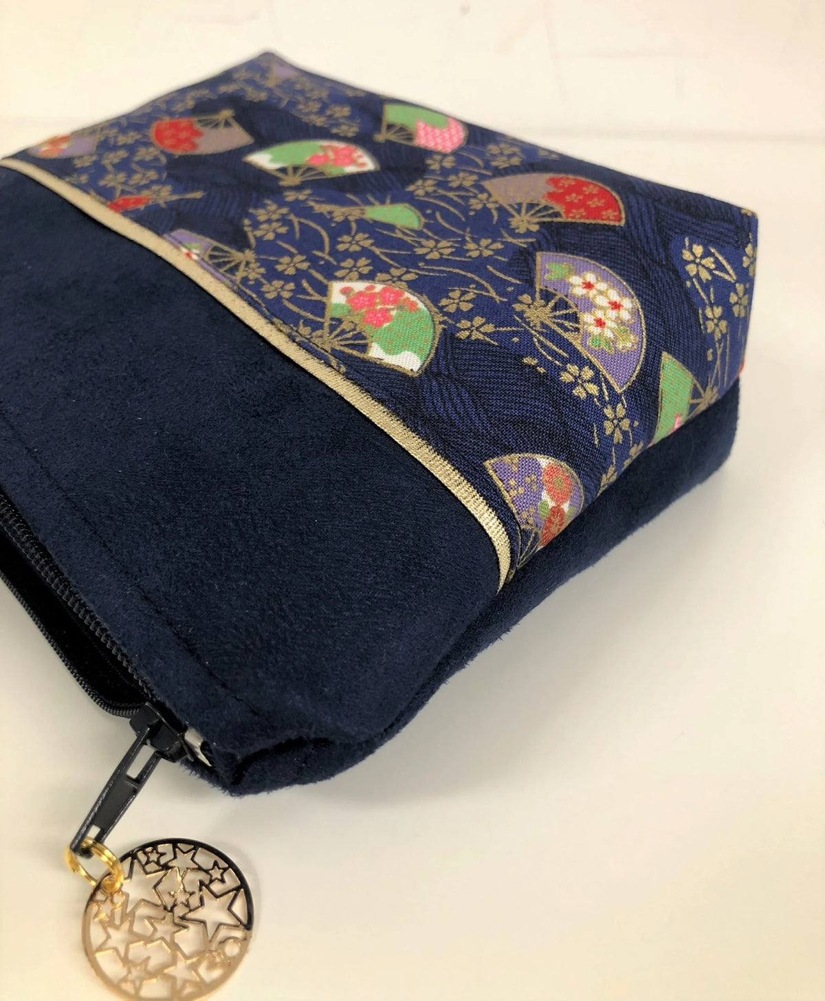 Vue latérale de la pochette à maquillage bleu marine en tissu japonais Sakura éventails.