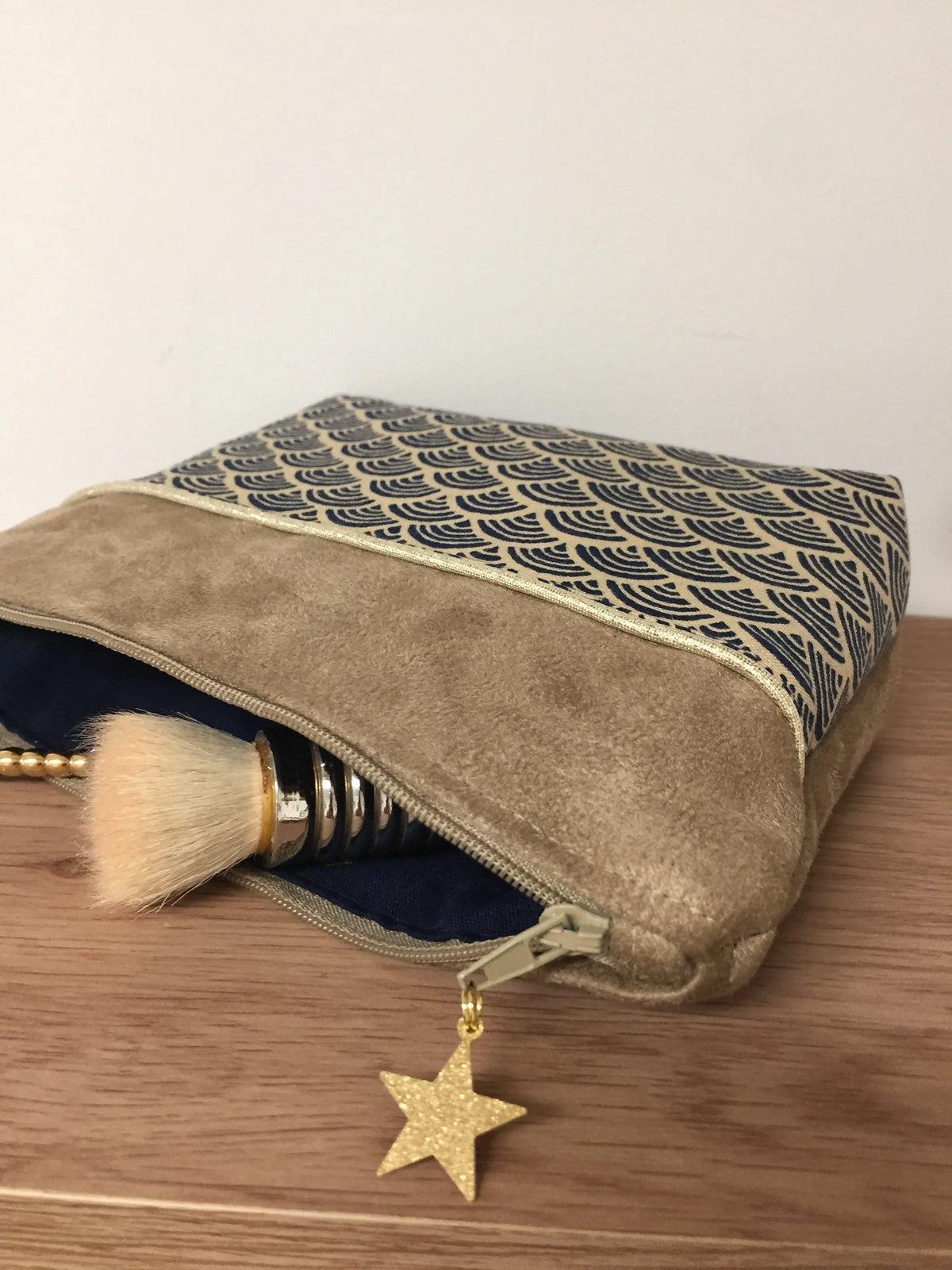 La pochette à maquillage camel en tissu japonais Seigaiha bleu marine, garnie de pinceaux.