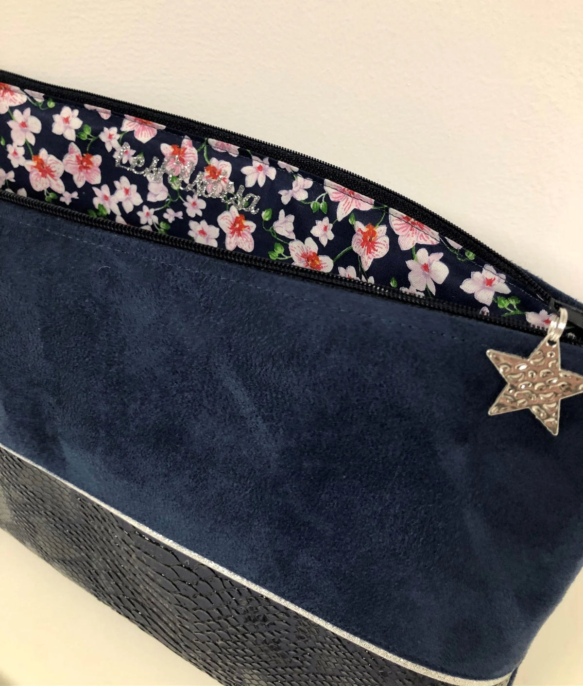 Vue ouverte de la pochette ordinateur bleu marine et argentée aspect reptile.