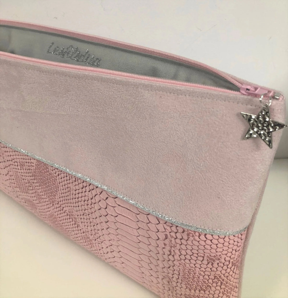Vue intérieure de la pochette ordinateur rose pâle et argentée aspect reptile.