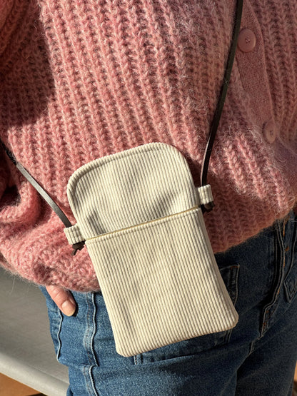 La pochette téléphone bandoulière en velours cotelé ivoire et cuir marron.