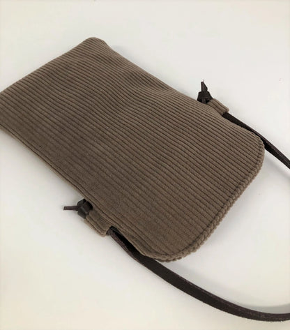 Le dos de la pochette téléphone bandoulière en velours cotelé marron chamois et cuir.