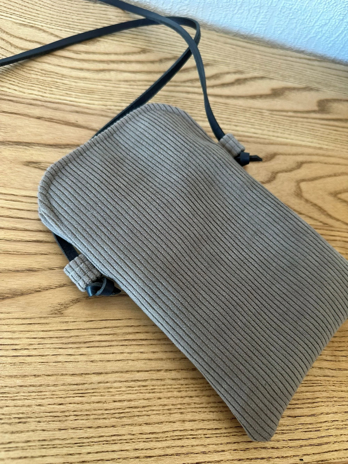 Le dos de la pochette téléphone en velours cotelé taupe .