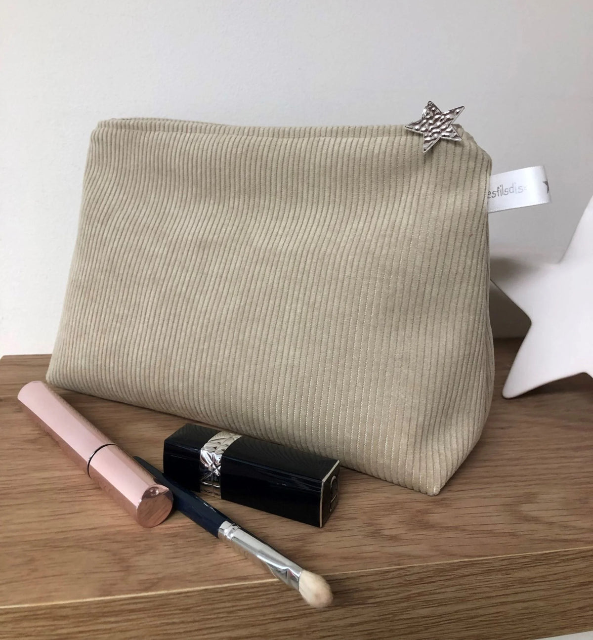 La pochette en velours côtelé beige sable, fermée