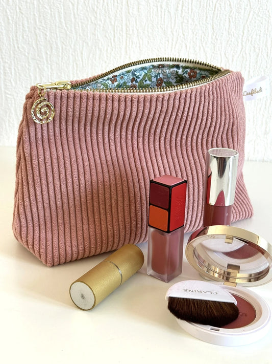 La pochette en velours côtelé rose blush, ouverte.