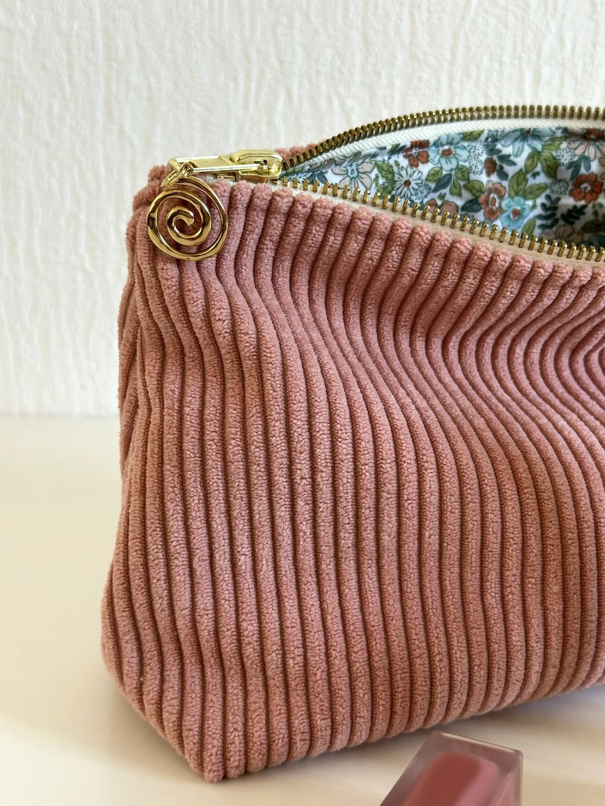 La breloque dorée de pochette en velours côtelé rose blush.