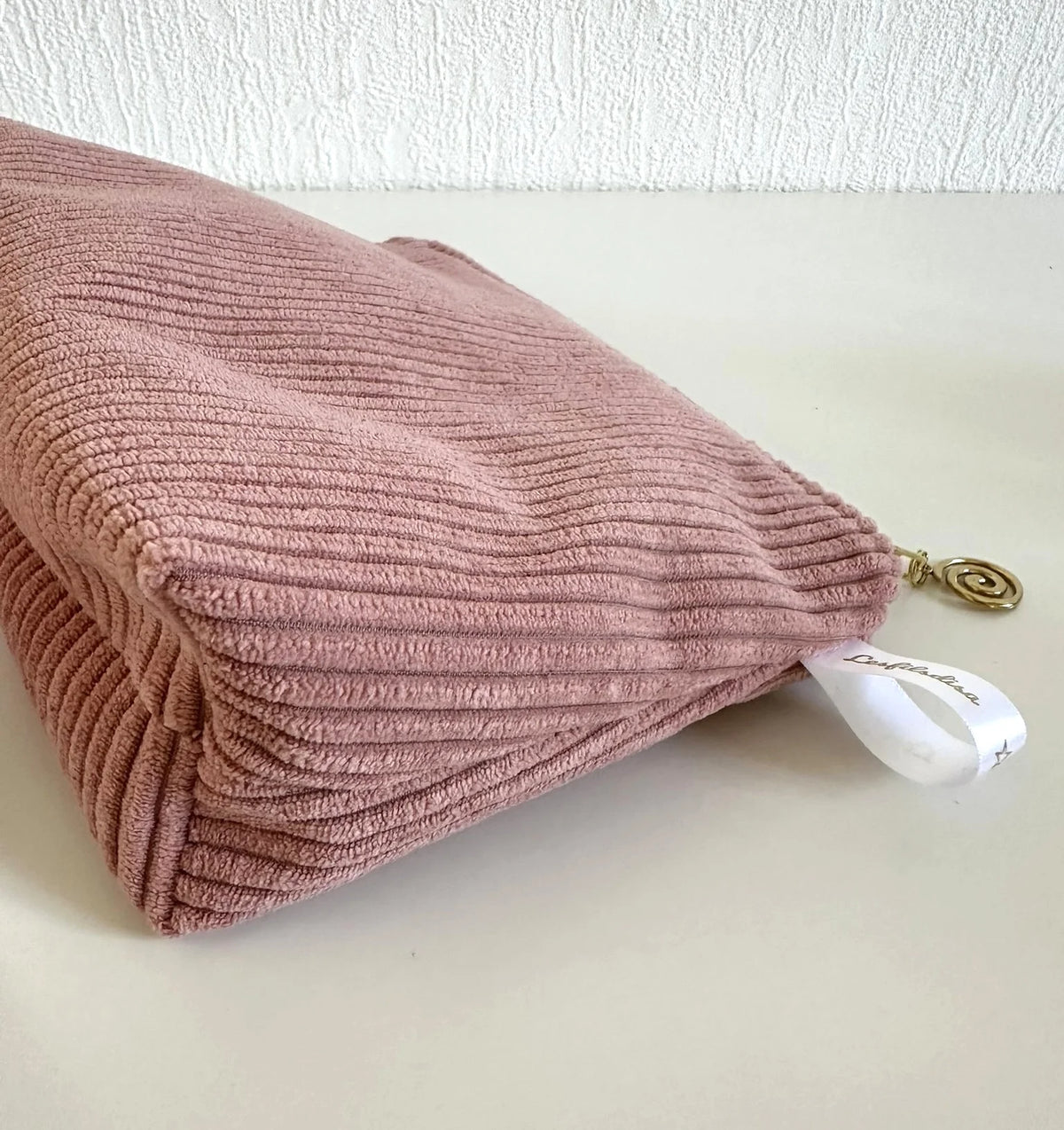 Vue latérale de la pochette en velours côtelé rose blush.