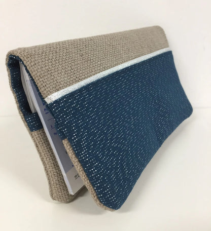 Vue latérale du porte-chéquier beige et bleu marine pailleté à liseré argenté.