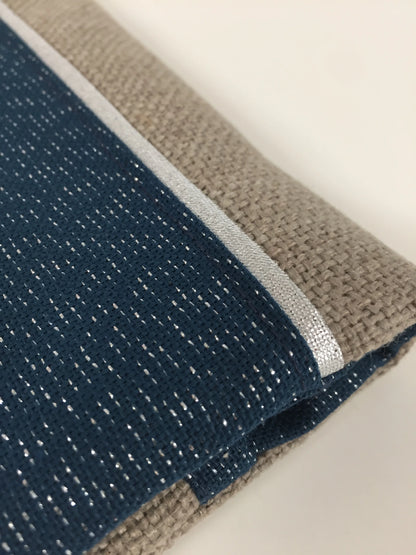 Vue détaillée du porte-chéquier beige et bleu marine pailleté à liseré argenté.