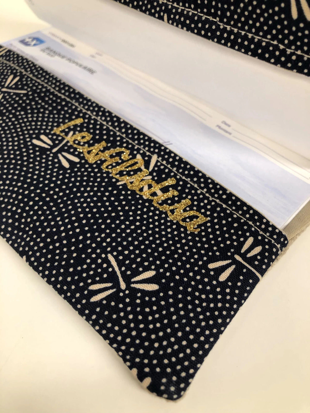 Le rabat inférieur du porte chéquier en lin beige et tissu japonais bleu libellules.