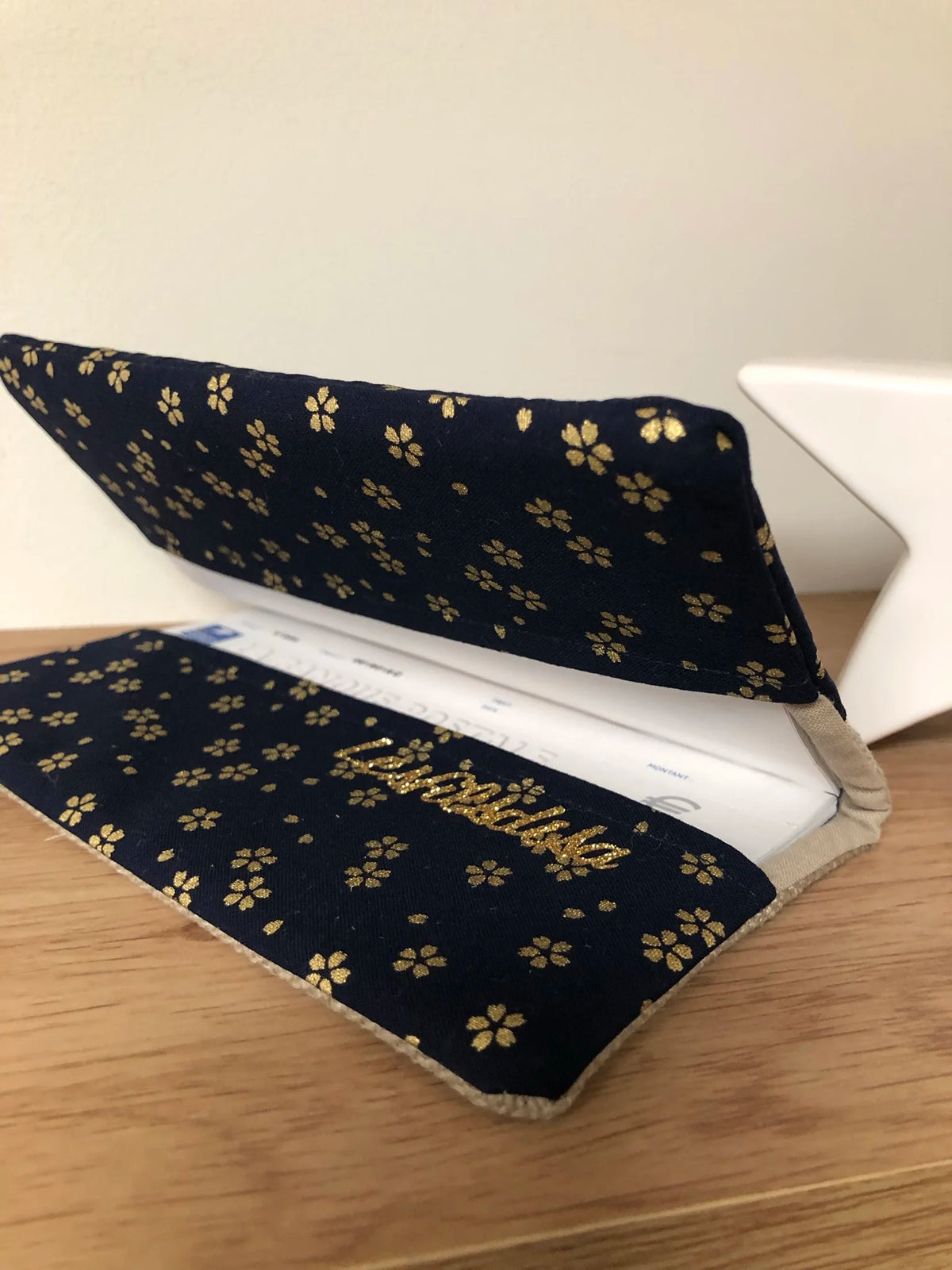 Le porte-chéquier en lin beige et tissu japonais Sakura bleu nuit, entrouvert.