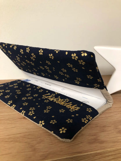 Le porte-chéquier en lin beige et tissu japonais Sakura bleu nuit, entrouvert.