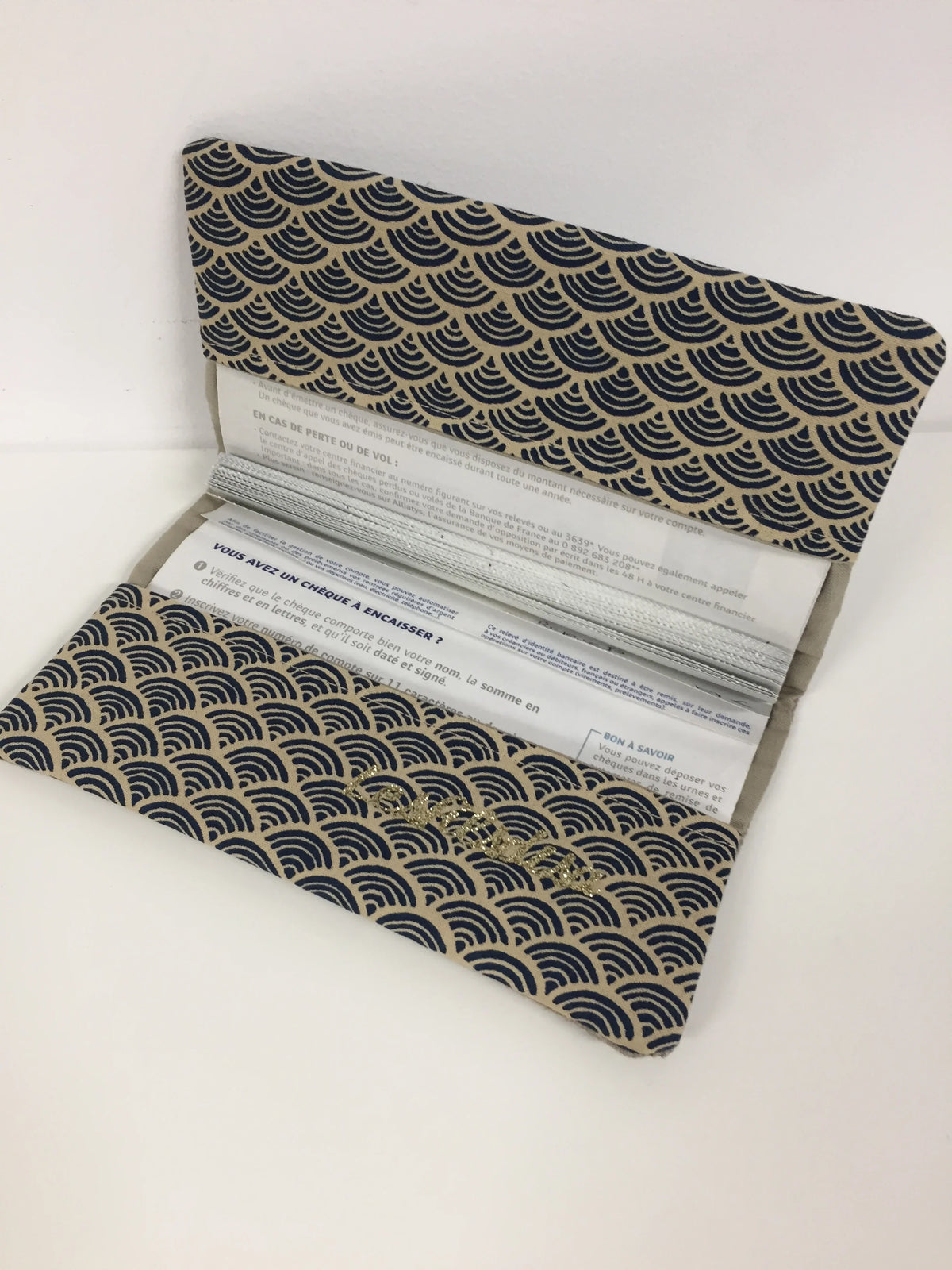 Le porte chéquier en lin beige et tissu japonais Seigaiha bleu marine, ouvert.