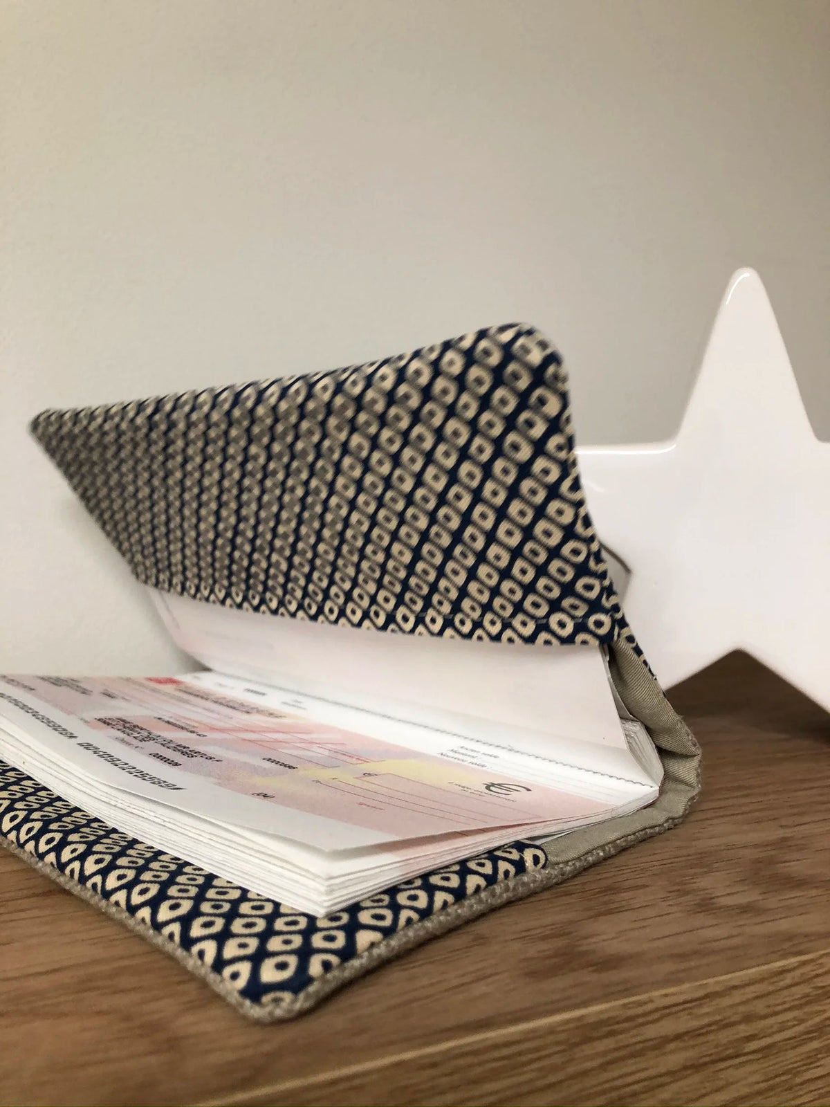 Le porte-chéquier en lin beige et tissu japonais Shibori bleu, entrouvert.