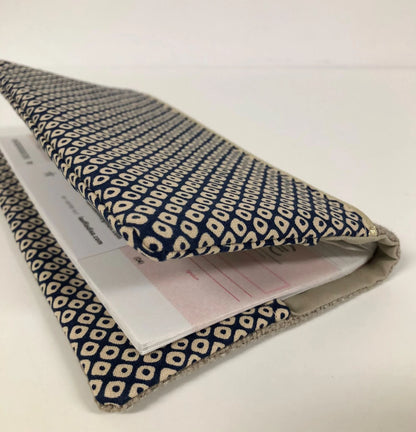 Chéquier installé dans le porte-chéquier en lin beige et tissu japonais Shibori bleu.