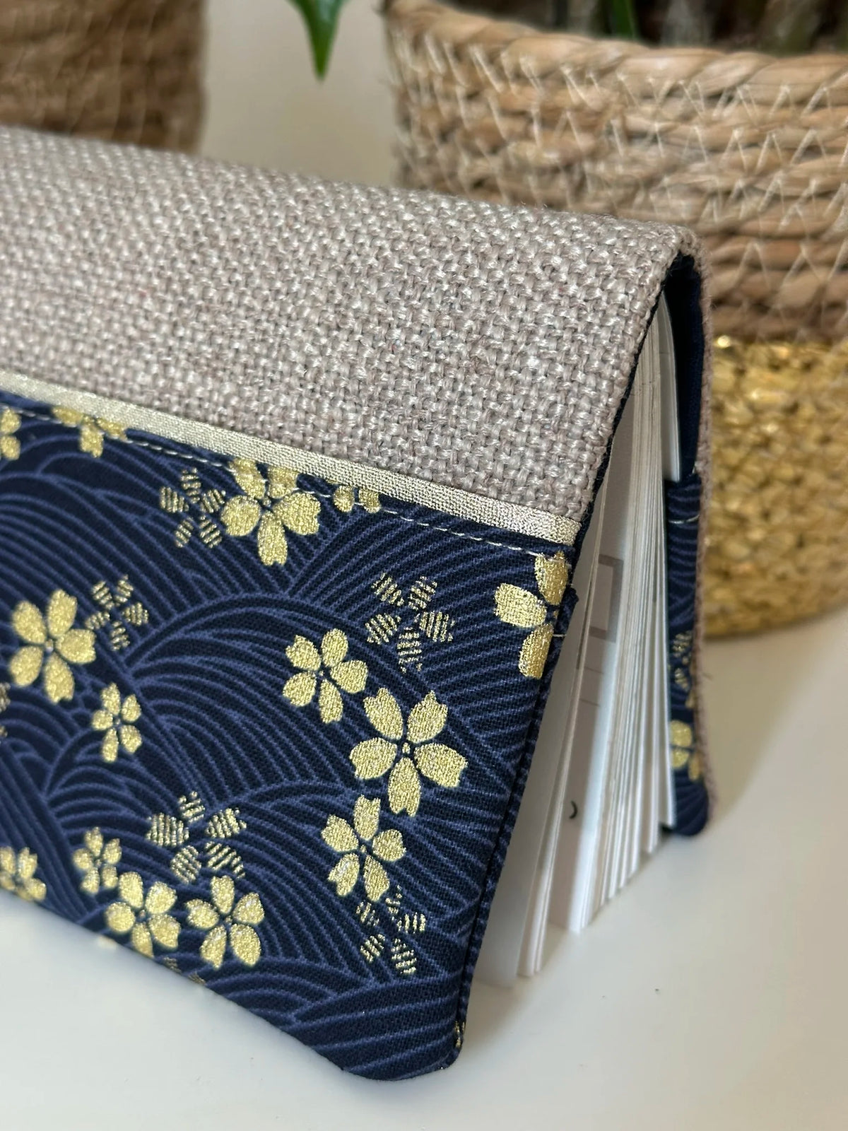 Les fleurs de cerisier dorées du porte chéquier en lin et tissu japonais Sakura bleu.